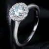 Halo ring close-up showing green moissanite center stone and sparkling white halo accent stones set in polished sterling silver S925 | D-Carats.