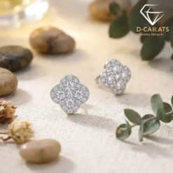 Close-up of sparkling moissanite earrings clover in silver platinum plating resting on a textured beige linen surface