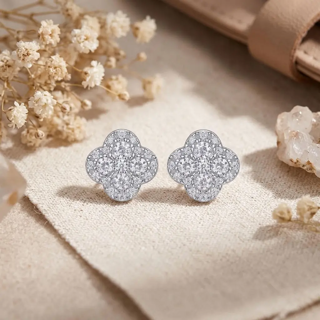 Clover earrings in platinum-plated 925 silver with moissanite 8 Close-up of sparkling moissanite earrings clover in platinum-plated silver resting on a neutral beige linen fabric surface