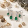 Close-up of pear-cut emerald drop earrings with silver plating and diamond accents showing precise 23mm by 14mm dimensions