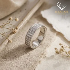 Close-up side view of a sparkling moissanite eternity band ring resting on textured beige linen with dried florals