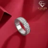 Moissanite eternity band ring in platinum-plated silver 25 Close-up angled view of a silver eternity band ring with two rows of sparkling moissanite stones on a red surface