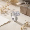 Moissanite Heart Halo Engagement Ring Set 22 Close-up of a silver heart shaped engagement ring set with sparkling moissanite stones and a matching curved wedding band