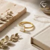 Close-up of a gold plated radiant cut engagement ring resting on a textured beige linen surface with soft natural sunlight