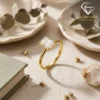 Close-up of a gold plated radiant cut engagement ring resting on a linen surface with soft natural sunlight and dried flora