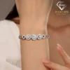 Close-up of a woman wearing a shimmering platinum silver triple halo moissanite bracelet with circular sparkling gems