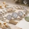 Close-up of polished silver triple halo gemstones resting on a textured stone surface with soft natural lighting