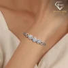 Close-up of a shimmering triple halo moissanite bracelet worn on a female wrist, showcasing polished platinum silver tones