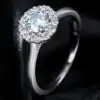Halo ring close-up showing green moissanite center stone and sparkling white halo accent stones set in polished sterling silver S925 | D-Carats.