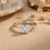 Silver band featuring an east west emerald cut moissanite stone with S925 hallmark in a soft sunlit setting