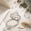 Marquise Moissanite Bridal Ring Set 20 Silver marquise moissanite bridal ring set with side baguettes and a curved band resting on a textured linen surface