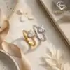 Halo Heart Ring 30 Two moissanite heart rings with halo settings displayed side by side on a soft beige fabric, one in silver and one in gold, surrounded by dried flowers and a ribbon