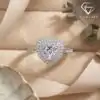 Front view of a silver heart ring double halo moissanite centered on beige velvet with a soft satin ribbon accent