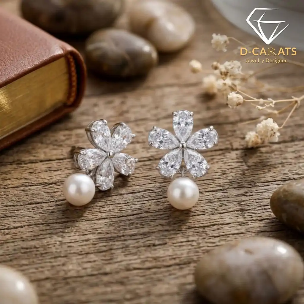 Pendientes colgantes de perla y plata con flor de circón 3 Primer plano de pendientes colgantes de perlas plateadas con pétalos florales de circón sobre una superficie de madera rústica y envejecida