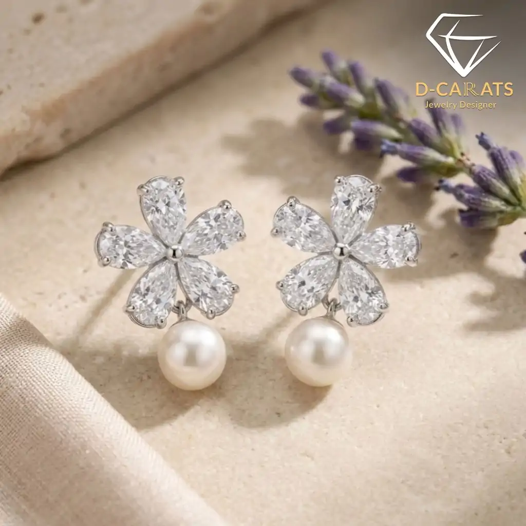 Pendientes colgantes de perla y plata con flor de circón 10 Plano detalle de pendientes colgantes de perla de plata con pétalos de circón talla marquesa y esferas crema sobre una superficie beige texturizada