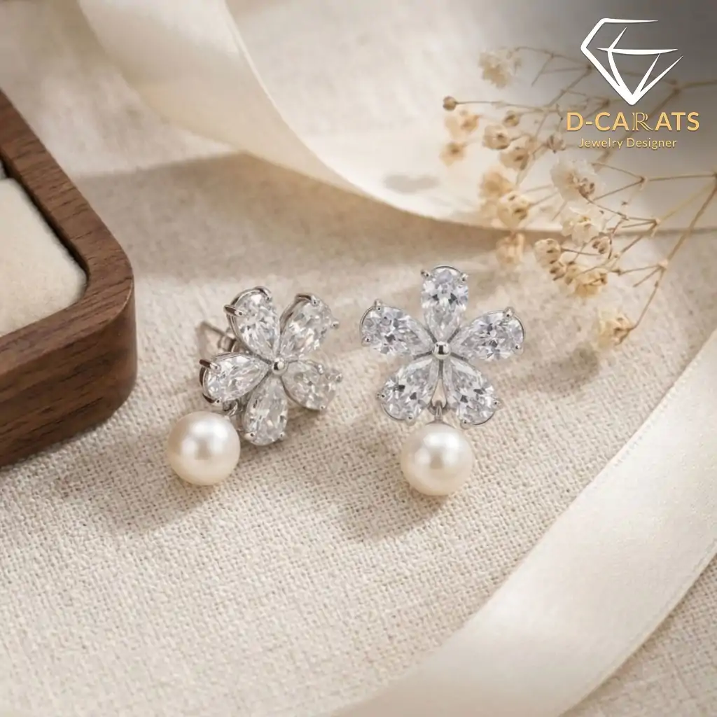 Pendientes colgantes de perla y plata con flor de circón 14 Primer plano de pendientes colgantes de perla de plata con flores de circón brillantes sobre una tela de lino crema con una cinta