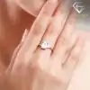 Three-stone emerald cut ring in 925 silver 17 Close-up of a polished silver three stone emerald cut ring worn on a female finger against soft skin tones
